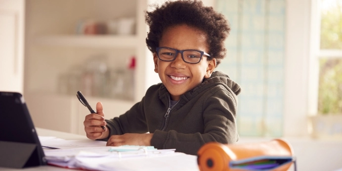 young kid wearing glasses while doing homework