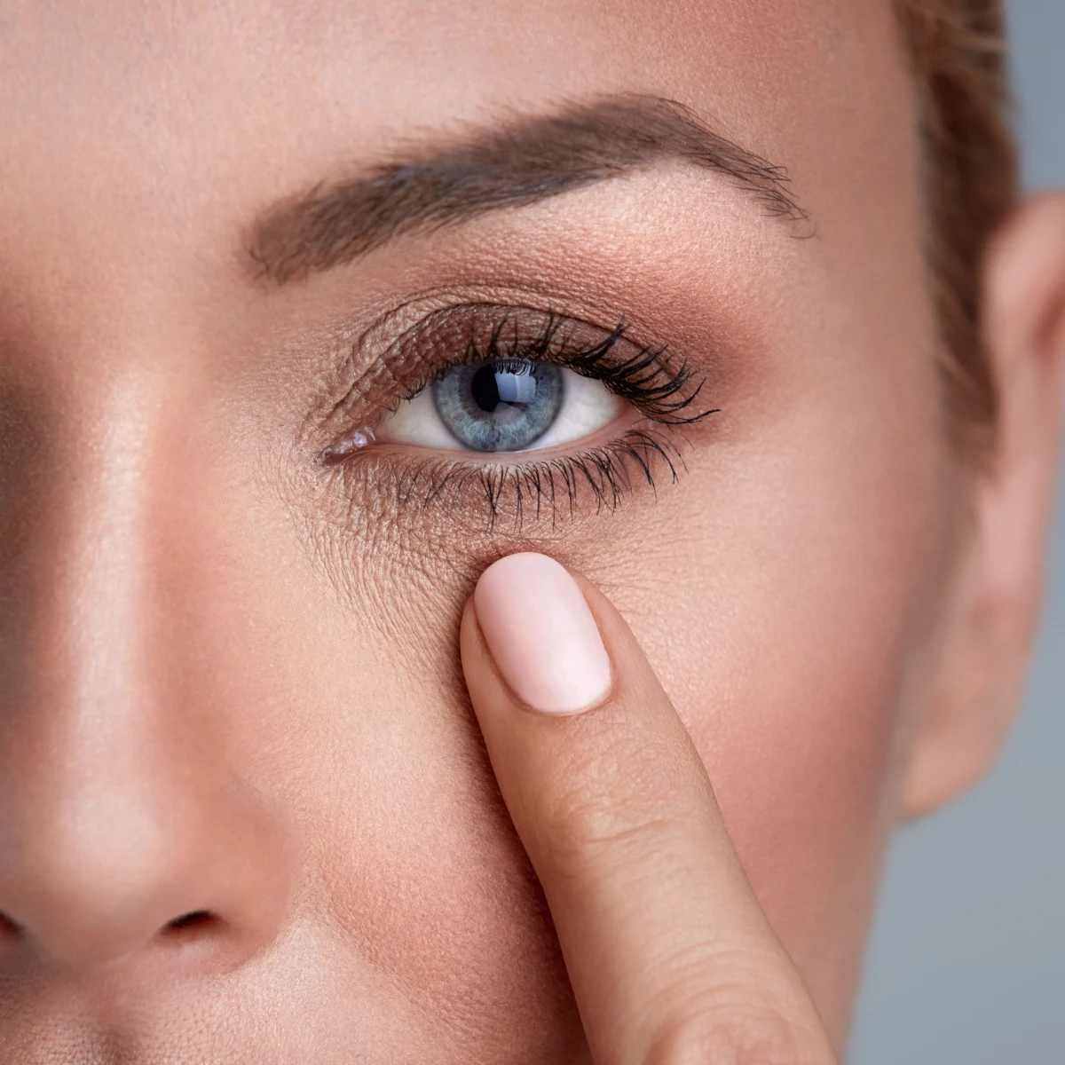 woman touching lower eyelid