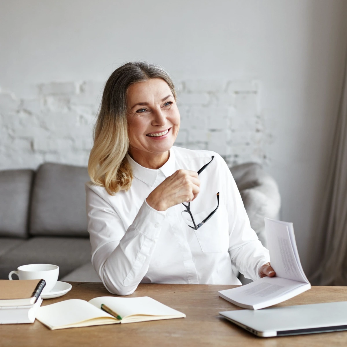 Joyful mature woman taking off glasses